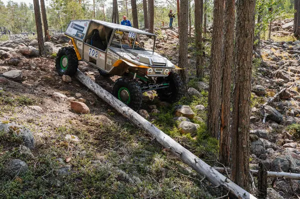 KARELIA, RUSSIA - CIRCA JUNE, 2022: Ladoga Gölü çevresindeki Off-road turnuvası Ladoga Kupası 2022. 4x4 Jeep arazi aracı ormanın ortasında kayaların üzerinden geçiyor.