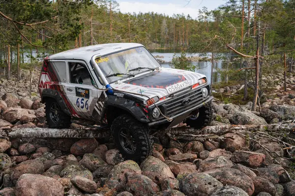 KARELIA, RUSSIA - CIRCA JUNE, 2022: Ladoga Gölü çevresindeki Off-road turnuvası Ladoga Kupası 2022. Off-road Jeep Niva 4x4 Karelia 'daki göl kenarındaki kayalıklarda yarışır.