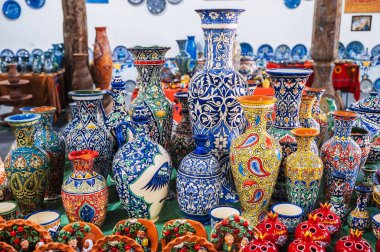 Özbekistan 'daki çömlekçilik atölyesindeki doğu dükkanında renkli Asya Özbek seramik vazoları ve sürahiler