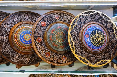 Özbek ahşap el yapımı hediye tabakları Özbekistan 'daki hediyelik eşya dükkanında elle boyanmış.