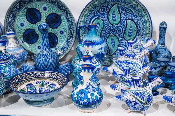 stock image Uzbek ceramic plates, jugs and dishes hand-painted in the oriental shop at the pottery workshop in Uzbekistan