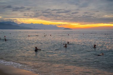 Vietnamlı Asyalılar sabah Nha Trang plajında denizde yüzerler. Nha Trang, Vietnam - 18 Temmuz 2024