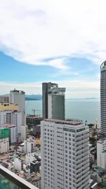 Bir yaz günü Vietnam 'da deniz ve plajla birlikte Nha Trang tatil beldesinin merkezindeki bir gökdelenin çatısından manzarayı izleyin. Nha Trang, Vietnam - 19 Temmuz 2024
