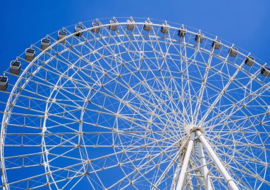 Beyaz büyük dönme dolap arka planda açık mavi gökyüzü lunaparkta fotokopi alanı ile