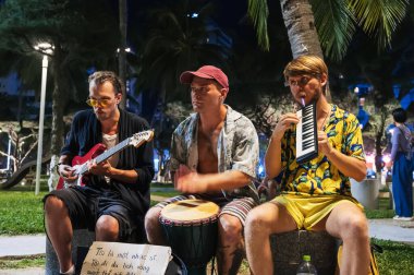 Enstrümanlı sokak müzisyenleri yazın Asya 'da bir parkta canlı müzik çalıyorlar. Nha Trang Vietnam - 24 Temmuz 2024