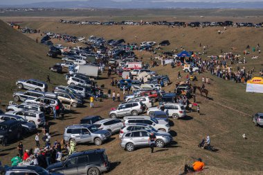 Bir sürü araba doğadaki otoparka park edilmiş ilkbaharda Kazakistan 'ın bozkırındaki festival karnavalında. Şymkent, Kazakistan - 17 Mart 2024