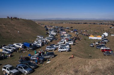 Bir sürü araba doğadaki otoparka park edilmiş ilkbaharda Kazakistan 'ın bozkırındaki festival karnavalında. Şymkent, Kazakistan - 17 Mart 2024