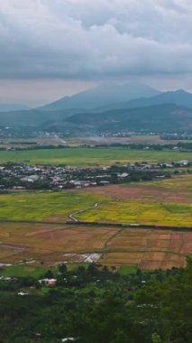 Asya 'da, Vietnam' daki dağların arka planında trenle seyahat eden pirinç tarlalarının en üst görüntüsü.