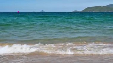 Yazın Nha Trang, Vietnam 'da bir tatil köyünde gökyüzünde dalgalanan açık mavi deniz.