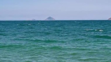 Yazın Nha Trang, Vietnam 'da bir tatil köyünde gökyüzünde dalgalanan açık mavi deniz.