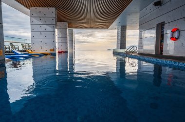 Denize bakan çatı havuzu olan lüks bir gökdelen otelinin içinde.