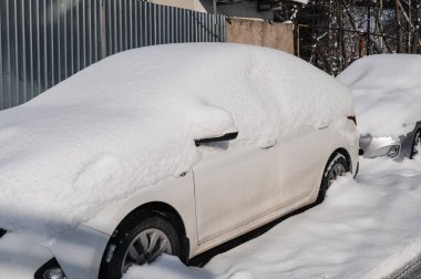Büyük kar tabakası ile kaplı bir sokakta araba