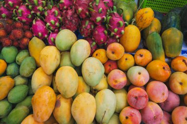Tayland 'daki bir markette tezgahın üzerinde çeşitli tropik Asya meyveleri var.