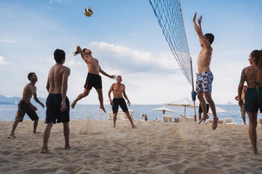 Çok uluslu insan takımları yazın Asya 'daki Nha Trang plajında plaj voleybolu oynuyorlar. Nha Trang, Vietnam - 4 Ağustos 2024