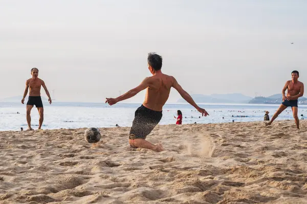 stock image Vietnamese men play beach soccer on the beach by the sea in summer in Nha Trang. Nha Trang, Vietnam - July 31, 2024