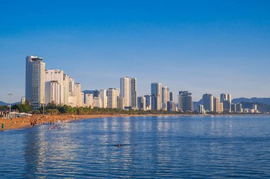 Deniz kenarındaki kumlu sahil manzarası ve yazın Asya sahillerindeki tatil köyündeki gökdelen otelleri. Nha Trang, Vietnam - 13 Ağustos 2024