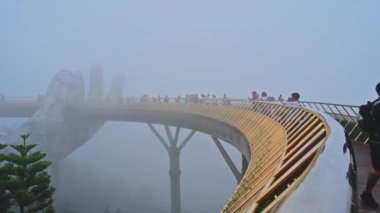 Ba Na Hills eğlence parkındaki Altın Köprü 'de yaz günü siste olan turistler. Da Nang, Vietnam - 13 Eylül 2024