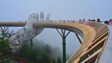 Yaz öğleden sonraları sis içinde turistlerin olduğu Sun World Ba Na Hills eğlence parkındaki Altın Köprü. Da Nang, Vietnam - 13 Eylül 2024