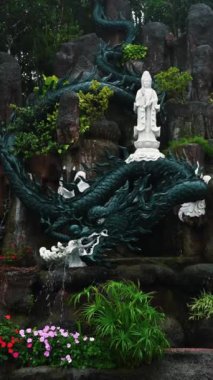Vietnam 'da Da Nang, Vietnam' daki Ba Na Hills Parkı 'ndaki bir pagoda bahçesindeki Budist heykeli ve ejderha çeşmesi.