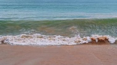 Yazın sahilde kumlu bir sahilde deniz dalgaları. Yavaş çekim