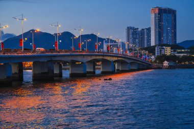 Tran Phu Bridge over the Cai River in Nha Trang at night. Panorama of Nha Trang city in Vietnam clipart