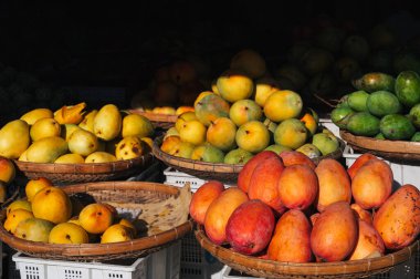 Asya 'da piyasada değişik mango çeşitleri var. Vietnam 'da bir sokak meyvecisinin tezgahında sarı, yeşil ve kırmızı mango.