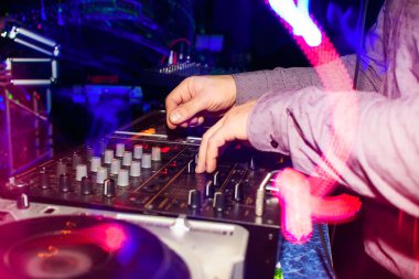 DJ eller, gece kulübündeki bir partide profesyonel mikserde müziği karıştırır.