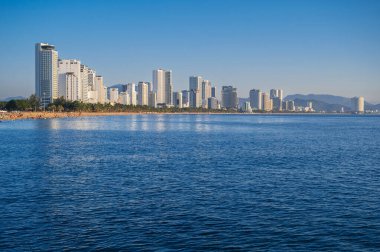 Vietnam 'da Nha Trang tatil köyü. Deniz kenarında kumlu bir plajı ve yazın otellerin gökdelenleri var.