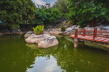 Yazın Asya 'da Budist Pagoda' nın bahçesindeki parkta kayalar ve köprü olan Japon göleti.