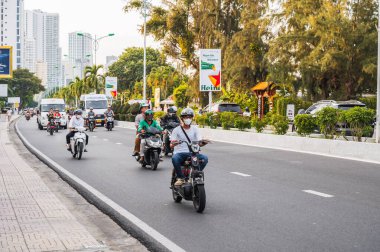 Asya 'da gün boyunca scooter kullanan Asyalı motosikletçilerin trafiği. Nha Trang, Vietnam - 20 Ağustos 2024