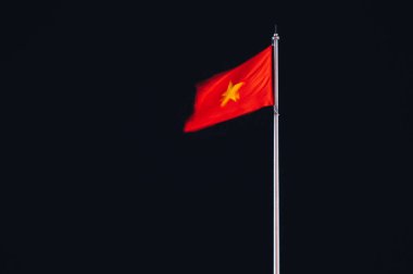 Vietnam flag blurred by the wind on flagpole at night clipart