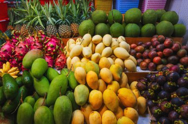 Asya 'da pazarda tropikal meyve çeşitleri. Vietnam 'da bir sokak dükkanında egzotik meyveler tezgahta. Mango, pitahaya, ananas, mangosteen ve tutku meyvesi