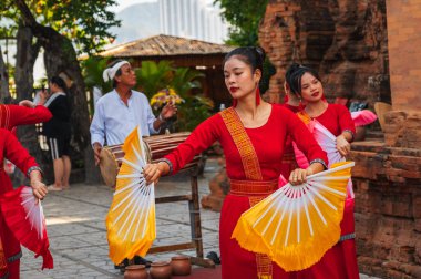 Hayranlarıyla geleneksel kırmızı elbiseli Vietnamlı kadınlar Asya 'daki Nha Trang' da Po Nagar Cham Kuleleri 'nde dans ediyorlar. Nha Trang, Vietnam - 8 Ağustos 2024