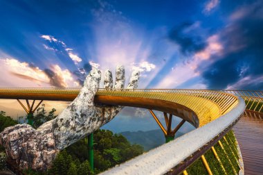 Güzel Altın Köprü ya da Tanrıların Eli Vietnam 'daki Ba Na Hills eğlence parkında yazın günbatımında dağın tepesinde.
