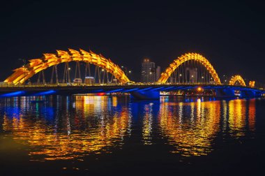 Han Nehri üzerindeki Ejderha Köprüsü, Vietnam 'ın Da Nang şehrinde geceleri altın ışıklarıyla ünlü bir simgedir.