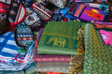 Asya 'da Vietnam' da bir sokak pazarında renkli çantalar ve çeşitli tekstil ürünleri tezgahın üzerinde.