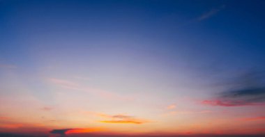 Mavi gökyüzü ve narin bulutlar yaz akşamında pembe bir günbatımı arka planında