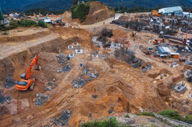 Construction site with excavators and other heavy construction equipment in the pit clipart