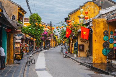 Hoi An 'da tarihi Asya tarzında geleneksel sarı evleri olan eski bir kasaba caddesi. Hoi An, Vietnam - 12 Eylül 2024