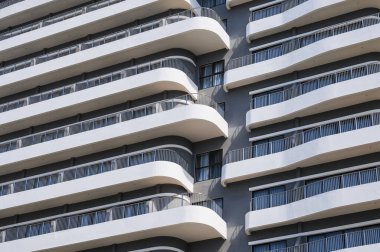 Geniş balkonları olan modern bir gökdelen apartmanı.