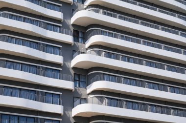 Geniş balkonlu modern bir gökdelen apartmanının ön tasarımı.