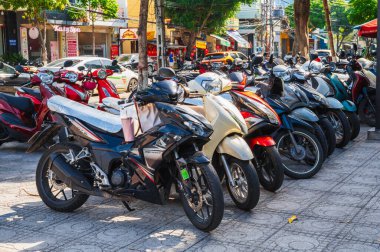 Motosikletli ve motosikletli bir motosiklet parkı, Vietnam şehir manzarasında duruyor. Nha Trang, Vietnam - 8 Eylül 2024