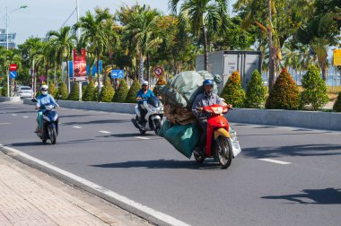 Vietnam yollarında trafik vardı. Gün boyunca, Asyalı bir adam scooterında büyük bir yük taşır. Nha Trang, Vietnam - 8 Eylül 2024