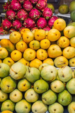 Mango ve ejderha meyvesinden yapılmış renkli bir meyve kutusu markette sergileniyor..