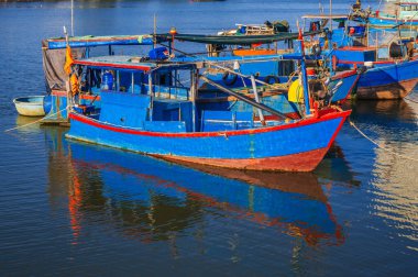 There are many traditional Vietnamese fishing boats and vessels in the bay on the river at Vinh Truong Fishing Port in Nha Trang, Vietnam clipart