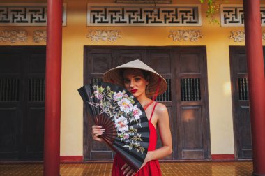 Vietnam 'da Vietnam' da Vietnam 'da Nha Trang' a seyahat ederken Vietnam 'da geleneksel bir şapkasız şapkalı güzel bir genç kadın turist.