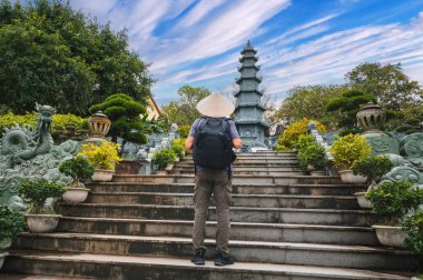 back of a male tourist traveler at the Linh Ung Pagoda in Da Nang in Vietnam. Concept of travel and tourism in Asia clipart