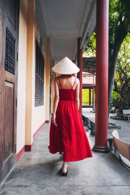 Vietnam 'daki bir pagoda tapınağında Non La şapkalı Vietnamlı bir turist kadının Asya' ya seyahati sırasında