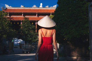 Vietnam 'daki bir pagoda tapınağında Non La şapkalı Vietnamlı bir turist kadının Asya' ya seyahati sırasında
