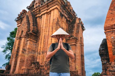 Vietnam 'da Nha Trang, Vietnam' daki antik Po Nagar Cham Kulelerinde dua eden Vietnamlı külah şapkalı bir adam. Asya 'da seyahat kavramı